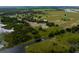 Expansive aerial view showing land with pond, dock, mature trees, and homes at 2350 Bradbury Rd, Haines City, FL 33844