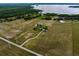 Aerial view of the property showcasing the main house, barn, lake, and surrounding land at 2350 Bradbury Rd, Haines City, FL 33844