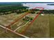Aerial view of the property lines showcasing the main house, barn, lake, and access to a road at 2350 Bradbury Rd, Haines City, FL 33844