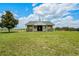 Wide shot of the barn exterior, with adjacent green pasture and fencing at 2350 Bradbury Rd, Haines City, FL 33844