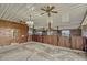Spacious barn interior featuring multiple horse stalls with wooden doors and metal accents, with overhead lighting and ceiling fans at 2350 Bradbury Rd, Haines City, FL 33844
