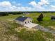 Aerial shot of barn with 3 stalls and a concrete apron surrounded by green pastures at 2350 Bradbury Rd, Haines City, FL 33844
