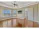 Light-filled bedroom with hardwood floors, a tray ceiling, and picturesque windows overlooking landscaped backyard at 2350 Bradbury Rd, Haines City, FL 33844
