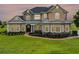 Elegant two-story home displaying lush landscaping, stone accents and a winding walkway to the covered front porch at 2350 Bradbury Rd, Haines City, FL 33844