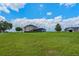 Spacious property featuring a large house, a barn, and an expansive lawn with clear blue skies overhead at 2350 Bradbury Rd, Haines City, FL 33844