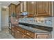Close-up of granite counters, cooktop, tile backsplash, and custom wood cabinets at 2350 Bradbury Rd, Haines City, FL 33844