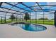 Enclosed pool area with waterfall feature and views of the surrounding landscape at 2350 Bradbury Rd, Haines City, FL 33844