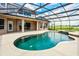 An outdoor pool with screen enclosure, water features, and views of the green pastures of the property at 2350 Bradbury Rd, Haines City, FL 33844