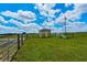 A small shed with a well-kept yard, surrounded by green grass under a bright blue sky at 2350 Bradbury Rd, Haines City, FL 33844