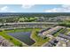 Scenic aerial shot of a community featuring a pond, townhomes, and a golf course surrounded by lush greenery at 2462 Sweet Viburnum Way, Ocoee, FL 34761