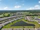 Aerial view of a new community with a pond, modern townhomes, and convenient access to highways and green spaces at 2462 Sweet Viburnum Way, Ocoee, FL 34761