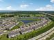 Aerial shot of new townhome community with a scenic pond, lush green spaces, and access to golf courses at 2462 Sweet Viburnum Way, Ocoee, FL 34761