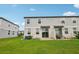 View of back of townhome with sliding glass doors and patio, showing backyard landscaping at 2462 Sweet Viburnum Way, Ocoee, FL 34761