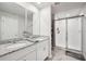 Well-lit bathroom featuring double sinks, granite counters, and a sleek glass-enclosed shower at 2462 Sweet Viburnum Way, Ocoee, FL 34761