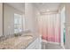 Modern bathroom featuring a granite countertop, single sink vanity, and shower with pink gradient curtain at 2462 Sweet Viburnum Way, Ocoee, FL 34761