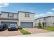 Charming two-story townhome with brick driveway, blue garage doors, and well-maintained landscaping at 2462 Sweet Viburnum Way, Ocoee, FL 34761