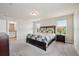 Bright main bedroom with neutral walls, carpet, ensuite bath, and natural light from dual windows at 2462 Sweet Viburnum Way, Ocoee, FL 34761