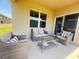 Cozy covered patio featuring comfortable seating and a glass table at 2569 Trinidad Rd, Haines City, FL 33844