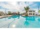 Large community pool with ample seating, clubhouse, and tropical landscaping on a sunny day at 2605 Scrapbook St, Kissimmee, FL 34746