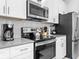 Well-equipped kitchen with stainless steel appliances and open shelving, perfect for cooking enthusiasts at 2605 Scrapbook St, Kissimmee, FL 34746