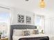 Bright main bedroom featuring a tufted headboard, modern lighting, and stylish decorative artwork at 2605 Scrapbook St, Kissimmee, FL 34746