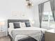 This bright bedroom features elegant decor, a stylish light fixture, and large windows at 2605 Scrapbook St, Kissimmee, FL 34746