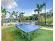 Outdoor ping pong table on green grass surrounded by tropical landscaping near community pool at 2605 Scrapbook St, Kissimmee, FL 34746