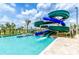 Community pool with a thrilling water slide and tropical landscaping on a sunny day at 2605 Scrapbook St, Kissimmee, FL 34746