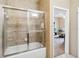 Bright bathroom featuring a tub and shower combination with glass doors and neutral tile surround at 3175 Feltrim Pl # 101, Kissimmee, FL 34747