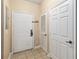 Condo entrance featuring a white door, tile flooring, and neutral paint color with easy access to other rooms at 3175 Feltrim Pl # 101, Kissimmee, FL 34747