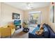 Comfortable living room with blue sofa, yellow chair, ceiling fan, and sliding glass doors with exterior view at 3175 Feltrim Pl # 101, Kissimmee, FL 34747