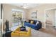 Comfortable living room with blue sofa, yellow chair, ceiling fan, and sliding glass doors with exterior view at 3175 Feltrim Pl # 101, Kissimmee, FL 34747