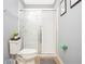 Bathroom with a toilet and a glass door shower, featuring a plant on top of the toilet at 3181 Tocoa Cir, Kissimmee, FL 34746