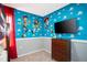 Fun 'Toy Story' themed bedroom featuring neutral carpet and a wall-mounted tv at 3181 Tocoa Cir, Kissimmee, FL 34746