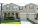 Inviting townhouse exterior with a two-car garage and well-maintained landscaping and beautiful shutters at 3181 Tocoa Cir, Kissimmee, FL 34746