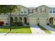 Inviting townhouse exterior with a two-car garage and well-maintained landscaping and beautiful shutters at 3181 Tocoa Cir, Kissimmee, FL 34746