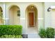 Inviting front porch with decorative arches, a warm wood door, and lush landscaping at 3181 Tocoa Cir, Kissimmee, FL 34746