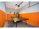 Spacious game room features ping pong table, storage, with orange and grey-painted walls at 3181 Tocoa Cir, Kissimmee, FL 34746