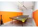Finished garage with an orange accent wall, a ping pong table, and a garage door at 3181 Tocoa Cir, Kissimmee, FL 34746