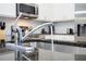 Close up of kitchen sink with chrome faucet, granite countertop, and stainless steel appliances in background at 3181 Tocoa Cir, Kissimmee, FL 34746