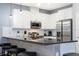 Well-lit kitchen with stainless steel appliances, white cabinets, and a spacious breakfast bar at 3181 Tocoa Cir, Kissimmee, FL 34746