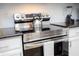 Stainless steel stove and oven with granite countertops and white kitchen cabinets in modern kitchen at 3181 Tocoa Cir, Kissimmee, FL 34746