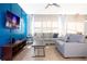 Relaxing living room with gray sofa, accent pillows, and large TV for entertainment at 3181 Tocoa Cir, Kissimmee, FL 34746