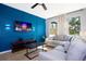 Comfortable living room with a stylish blue accent wall, large windows, and modern decor at 3181 Tocoa Cir, Kissimmee, FL 34746
