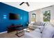 Comfortable living room with a stylish blue accent wall, large windows, and modern decor at 3181 Tocoa Cir, Kissimmee, FL 34746