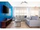 Relaxing living room with gray sofa, accent pillows, and large TV for entertainment at 3181 Tocoa Cir, Kissimmee, FL 34746