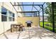 Outdoor patio features a grill and outdoor dining table and chairs within a screened in enclosure at 3181 Tocoa Cir, Kissimmee, FL 34746