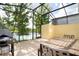 Outdoor patio features a grill and outdoor dining table and chairs within a screened in enclosure at 3181 Tocoa Cir, Kissimmee, FL 34746