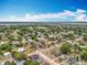 Wide aerial shot of a residential neighborhood with tree-lined streets and a glimpse of a lake in the distance at 320 S Seminole Ave, Lake Alfred, FL 33850