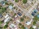 Birds eye view of neighborhood with solar panels, pools, mature trees, and neatly arranged streets, offering comfortable living at 320 S Seminole Ave, Lake Alfred, FL 33850